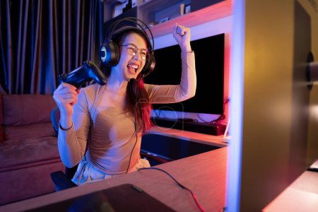 Foto de Asiático moderno mujer gamer tener seria juego divertido en un RGB-iluminado sala de juegos. - Imagen libre de derechos