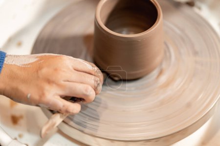 Photo for Earthenware The art of sculpting clay with ceramics being molded by hand on a spinning machine. with the right posture to create a plate or vase professionally - Royalty Free Image