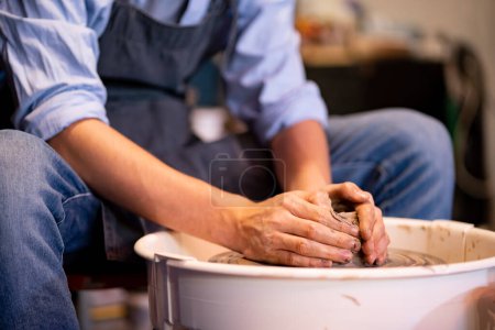 Téléchargez les photos : Faïence L'art de sculpter l'argile avec de la céramique moulée à la main sur une machine à filer. avec la bonne posture pour créer une assiette ou un vase professionnellement - en image libre de droit