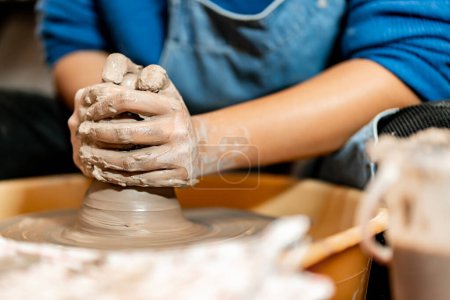 Foto de Loza El arte de esculpir arcilla con cerámica que se moldea a mano en una máquina de hilar. con la postura correcta para crear un plato o jarrón profesionalmente - Imagen libre de derechos