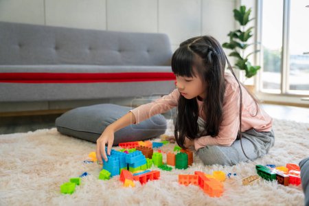 Téléchargez les photos : Asiatique fille photos Jouer bloc puzzle jeux à la maison ensemble avoir du plaisir et le bonheur. - en image libre de droit