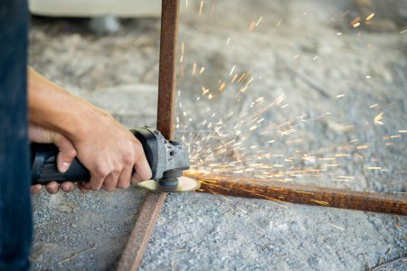 Photo for A blacksmith is using a sharpener, sparks come out while cutting. - Royalty Free Image