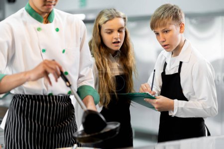 Foto de Los estudiantes están aprendiendo a cocinar en un instituto culinario con una cocina estándar y equipo completo. Y tener un chef profesional como entrenador. - Imagen libre de derechos