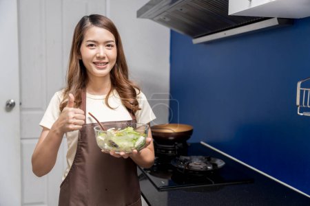 Foto de Mujer asiática haciendo ensalada de alimentos saludables Para cuidar la salud coma alimentos que son beneficiosos para el cuerpo Hágalo con limpieza, como lavarse la mano antes de lavarse los síntomas antes de comer - Imagen libre de derechos