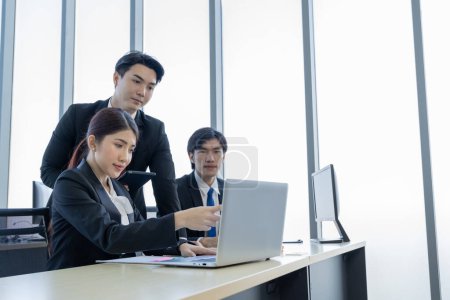 Téléchargez les photos : Un groupe de jeunes hommes d'affaires asiatiques Parler et planifier travailler heureux et s'amuser. au bureau de l'entreprise - en image libre de droit