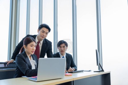 Téléchargez les photos : Un groupe de jeunes hommes d'affaires asiatiques Parler et planifier travailler heureux et s'amuser. au bureau de l'entreprise - en image libre de droit