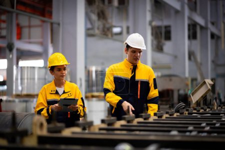 Photo for Team of young male and female engineers in a metal sheet factory Responsible work is being inspected at the actual work site. Work professionally and happily - Royalty Free Image