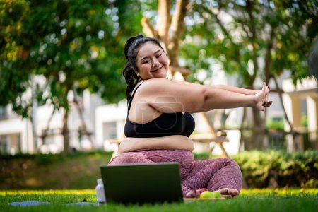 Téléchargez les photos : Une femme obèse qui se tourne vers l'exercice pour prendre soin de la santé et perdre du poids sur la pelouse d'une manière amusante. - en image libre de droit