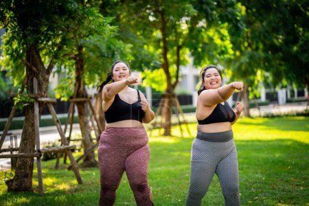 Photo for An obese women who turns to exercise to take care of health and lose weight on the lawn in a fun way. - Royalty Free Image
