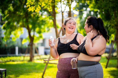 Foto de Una mujer obesa que recurre al ejercicio para cuidar la salud y perder peso en el césped de una manera divertida. - Imagen libre de derechos