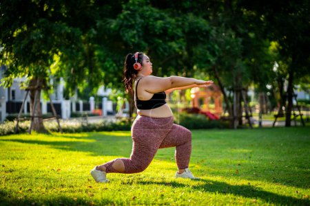 Téléchargez les photos : Une femme obèse qui se tourne vers l'exercice pour prendre soin de la santé et perdre du poids sur la pelouse d'une manière amusante. - en image libre de droit