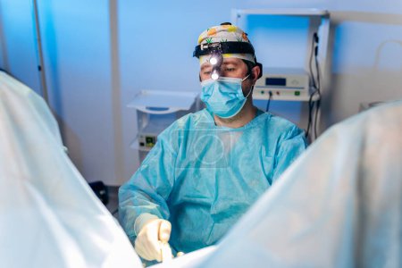 Chirurgien professionnel proctologue effectuant une opération à l'aide de dispositifs médicaux spéciaux dans la salle d'opération de l'hôpital. Concept chirurgical urgent