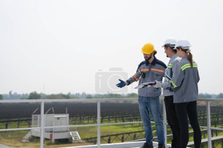Foto de Reunión de ingenieros para comprobar el panel solar en la azotea. granja solar con un sistema de almacenamiento de energía operado por Super Energy Corporation Especialistas reunidos para pruebas al aire libre Módulo de células fotovoltaicas. - Imagen libre de derechos