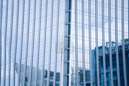 Foto de Perspectiva y ángulo inferior vista al fondo texturizado de la fachada de vidrio contemporáneo de los rascacielos del edificio de la achitecture con la luz refleja del cielo y de la nube. (Forma de curva de detalle de vidrio mullion) - Imagen libre de derechos