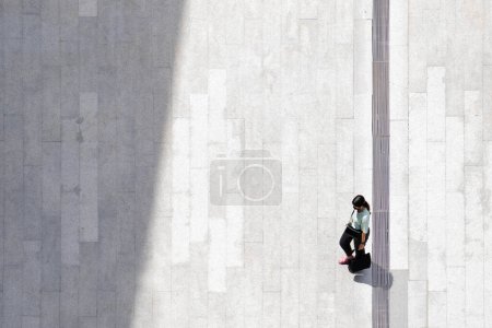 Foto de Vista aérea superior mujer personas caminan a través de hormigón peatonal con sombra de silueta negro en el suelo, concepto de naturaleza muerta social. - Imagen libre de derechos