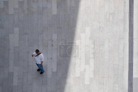 Photo for Top aerial view man people walk on across pedestrian concrete with black silhouette shadow on ground, concept of social still life. - Royalty Free Image