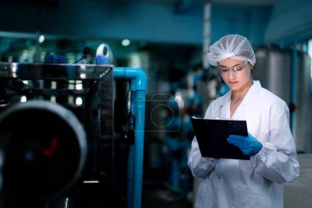 Photo for Factory woman worker checking water bottles in the warehouse at the industrial factory. Female worker recording data at the beverages manufacturing line production. - Royalty Free Image