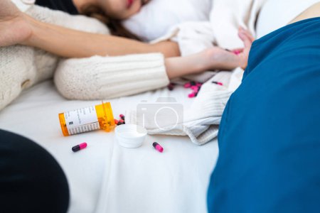 Photo for Many multi-colored pills in a woman hands. Painful teen age. Drug abuse concept - passive hand on bed. Close up of overdose pills and addict. woman wake up the friend female body in background. - Royalty Free Image