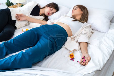 Photo for Many multi-colored pills in a woman hands. Painful teen age. Drug abuse concept - passive hand on bed. Close up of overdose pills and addict. woman wake up the friend female body in background. - Royalty Free Image