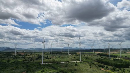 Téléchargez les photos : Le vent aérien des éoliennes produit de l'énergie extricée dans le parc éolien. La technologie pour la durabilité des ressources énergétiques pour l'avenir et les changements climatiques. construction de moulins à vent en zone rurale. - en image libre de droit