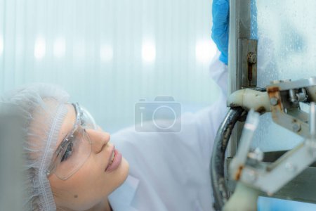 Photo for Factory woman engineer inspecting water dispenser on the machine. The worker checks the quality of water bottles on the machine conveyor line at the industrial factory. - Royalty Free Image