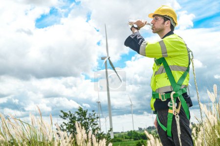 Photo for Worker drinking water. Technicians of wind turbine checking and maintenance Electricity wind generator.. operation of wind turbines that convert wind energy into electrical energy - Royalty Free Image