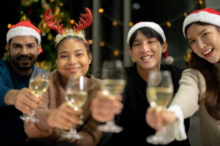 Photo for Close up glasses of clinking glasses of champagne with lighting. Party of asian friend female and male celebrating. happiness friends christmas eve celebrate dinner party with food and champagne. - Royalty Free Image