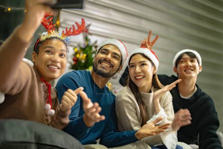 Foto de Fiesta de amigos asiáticos Disfrutando de las bebidas navideñas y celebrando tener selfie por smartphone. la felicidad de las mujeres y el hombre la víspera de Navidad celebrar la cena con comida y bebida. - Imagen libre de derechos