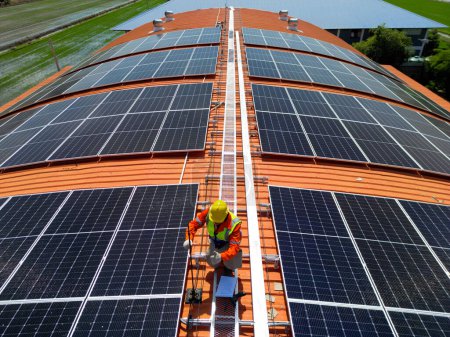 Photo for Engineer man inspects construction of solar cell panel or photovoltaic cell at roof top. Industrial Renewable energy of green power. factory at urban area. worker working on tower roof. - Royalty Free Image