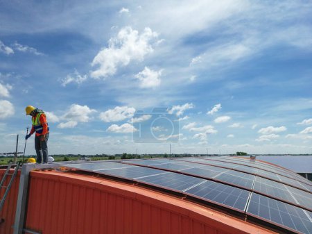 Photo for Engineer man inspects construction of solar cell panel or photovoltaic cell at roof top. Industrial Renewable energy of green power. factory at urban area. worker working on tower roof. - Royalty Free Image