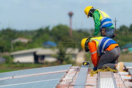 Foto de Técnicos de los trabajadores están trabajando para construir el sistema de paneles solares en el techo. Instalación del sistema solar fotovoltaico. Concepto ecológico de energía alternativa. Concepto de tecnología de energía limpia renovable. - Imagen libre de derechos