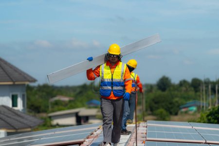 Foto de Técnicos de los trabajadores están trabajando para construir el sistema de paneles solares en el techo. Instalación del sistema solar fotovoltaico. Concepto ecológico de energía alternativa. Concepto de tecnología de energía limpia renovable. - Imagen libre de derechos