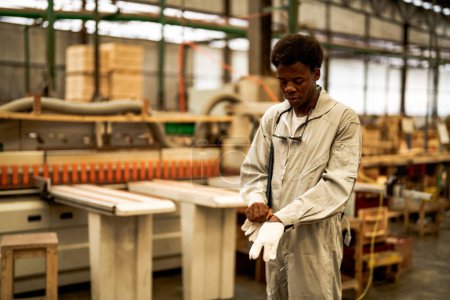 Photo for African man workers engineering standing with confidence with working suite dress and hand glove in front machine. Concept of smart industry worker operating. Wood factory produce wood palate. - Royalty Free Image