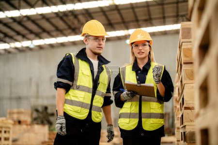 Photo for Workers man and woman engineering walking and inspecting timbers wood in warehouse. Concept of smart industry worker operating. Wood factories produce wood palate. - Royalty Free Image