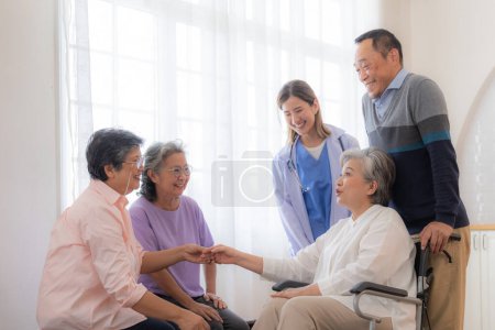 Téléchargez les photos : Asiatique jeune infirmière soutenir couple homme âgé et femme dans un fauteuil roulant. personnes âgées matures et un groupe d'amis âgés vivant à l'hôpital. socialisation des retraités. - en image libre de droit