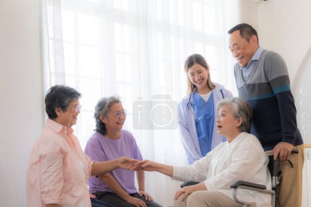 Photo for Asian young nurse support couple senior older man and woman in a wheelchair. elderly mature and a group of senior friends living in the hospital. socializing of retired people. - Royalty Free Image