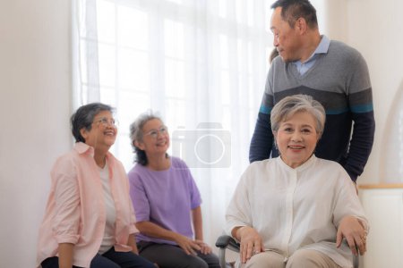 Téléchargez les photos : Asiatique jeune infirmière soutenir couple homme âgé et femme dans un fauteuil roulant. personnes âgées matures et un groupe d'amis âgés vivant à l'hôpital. socialisation des retraités. - en image libre de droit