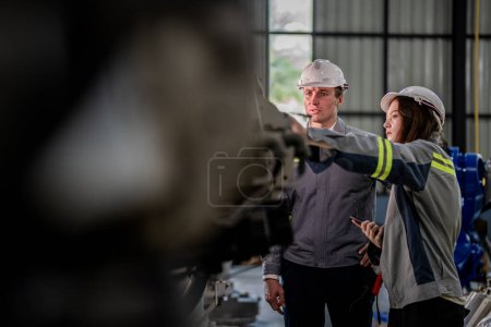 Photo for Factory engineer woman inspecting on machine with smart tablet. Worker works at machine robot arm. The welding machine with a remote system in an industrial factory. Artificial intelligence concept. - Royalty Free Image