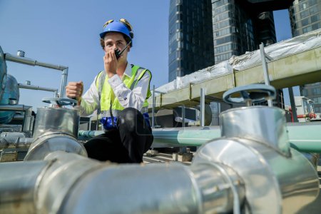 engineer inspecting HVAC equipment with a tablet on a building rooftop. An engineer attentively checks pipework on a rooftop against a cityscape, using a tablet for data analysis in urban maintenance.