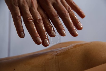 hand massage of a masseuse in oil close-up doing a massage in a spa salon