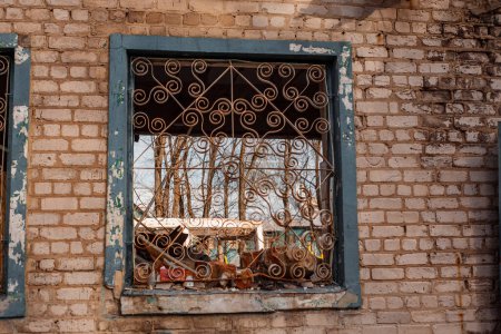 window with bars without glass in a destroyed cafe in Ukraine
