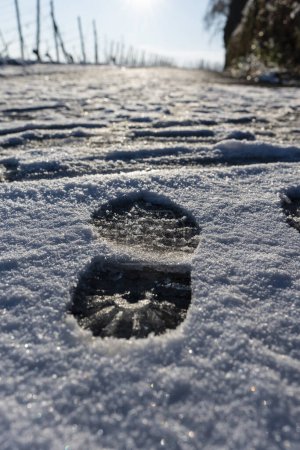 Menschliche Fußabdrücke im Schnee unter Sonnenlicht aus nächster Nähe. Ein Fußabdruck im Schnee.
