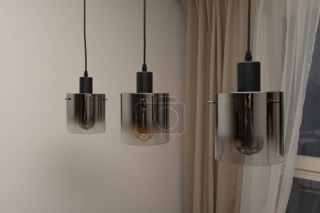 Foto de Tres lámparas colgantes en forma de cilindro con vidrio teñido. Tres lámparas modernas. - Imagen libre de derechos