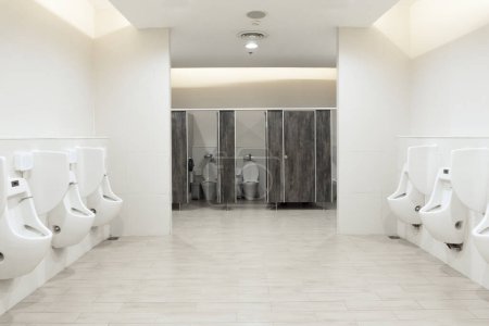 Photo for Men's room urinals discharge ,Toilet bowl in a modern bathroom with bins and toilet paper,flush toilet clean bathroom - Royalty Free Image