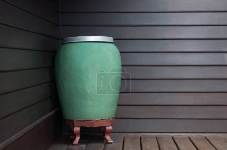 Téléchargez les photos : Art grand pot vert d'eau fait à la main en céramique sur fond en bois mural, pot vert en céramique avec de l'eau pot ancien et merveilleux - en image libre de droit