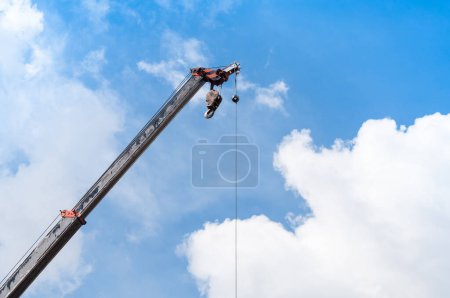 Foto de Brazo de grúa móvil con gancho colgado por cable de alambre fondo cielo azul, primer plano - Imagen libre de derechos