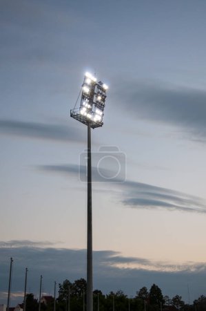 Foto de Luces del estadio en un campo de deportes en la noche con dilapidated - Imagen libre de derechos