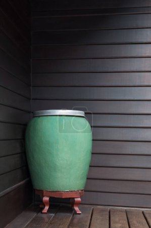 Téléchargez les photos : Art grand pot vert d'eau fait à la main en céramique sur fond en bois mural, pot vert en céramique avec de l'eau pot ancien et merveilleux - en image libre de droit