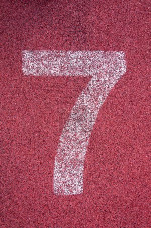 Foto de Número siete en la pista. Número de pista blanca en pista de carreras de goma roja, textura de pistas de carreras en estadio - Imagen libre de derechos