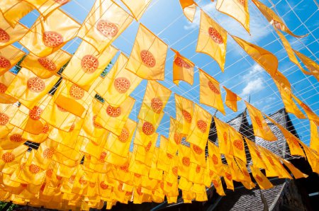 Photo for Thammachak flag yellow in temple (Wat Phan tao) on blue sky temple Northern Thailand - Royalty Free Image